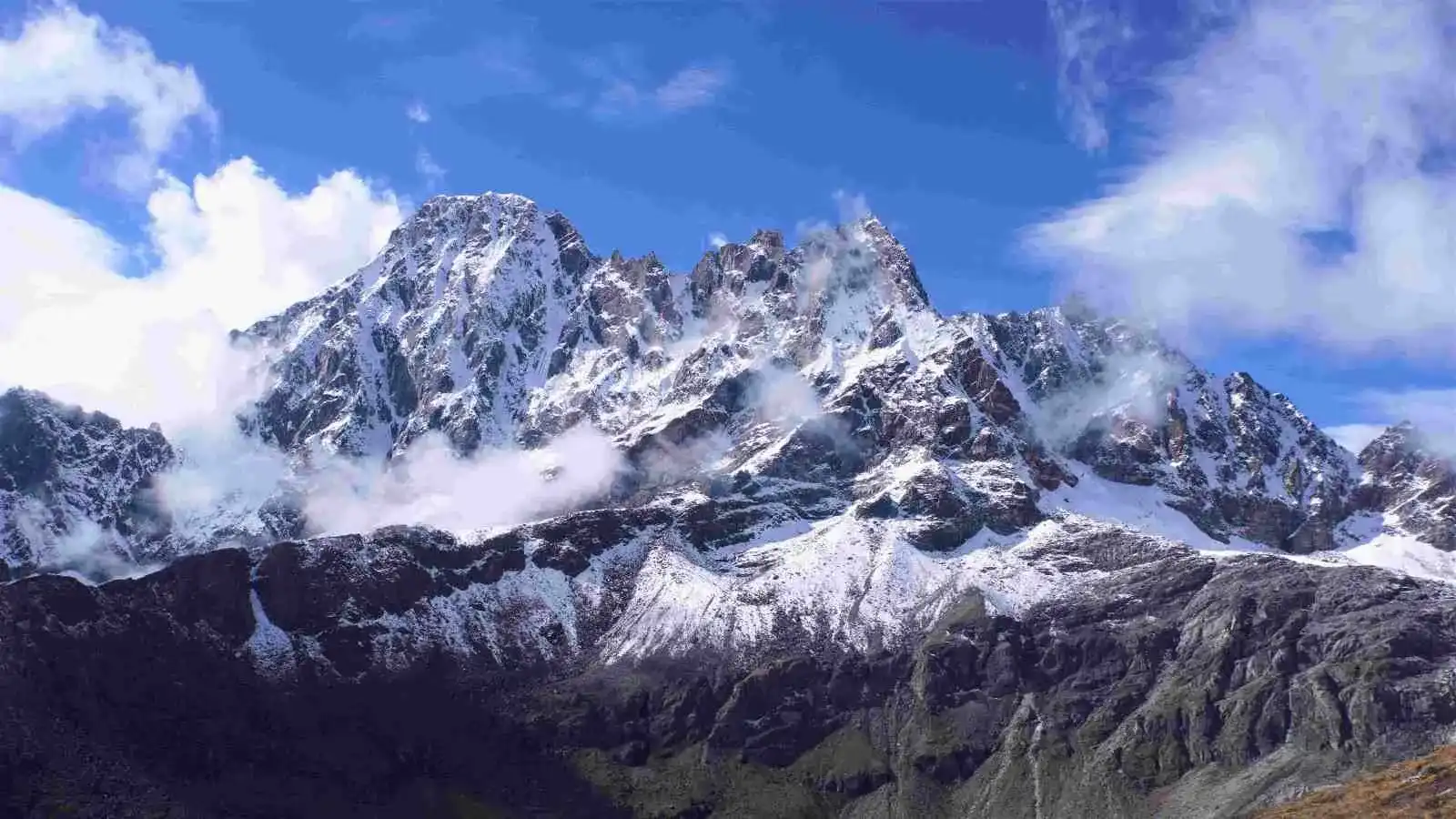 Trekker crossing Cho La Pass with prayer flags and mountain views