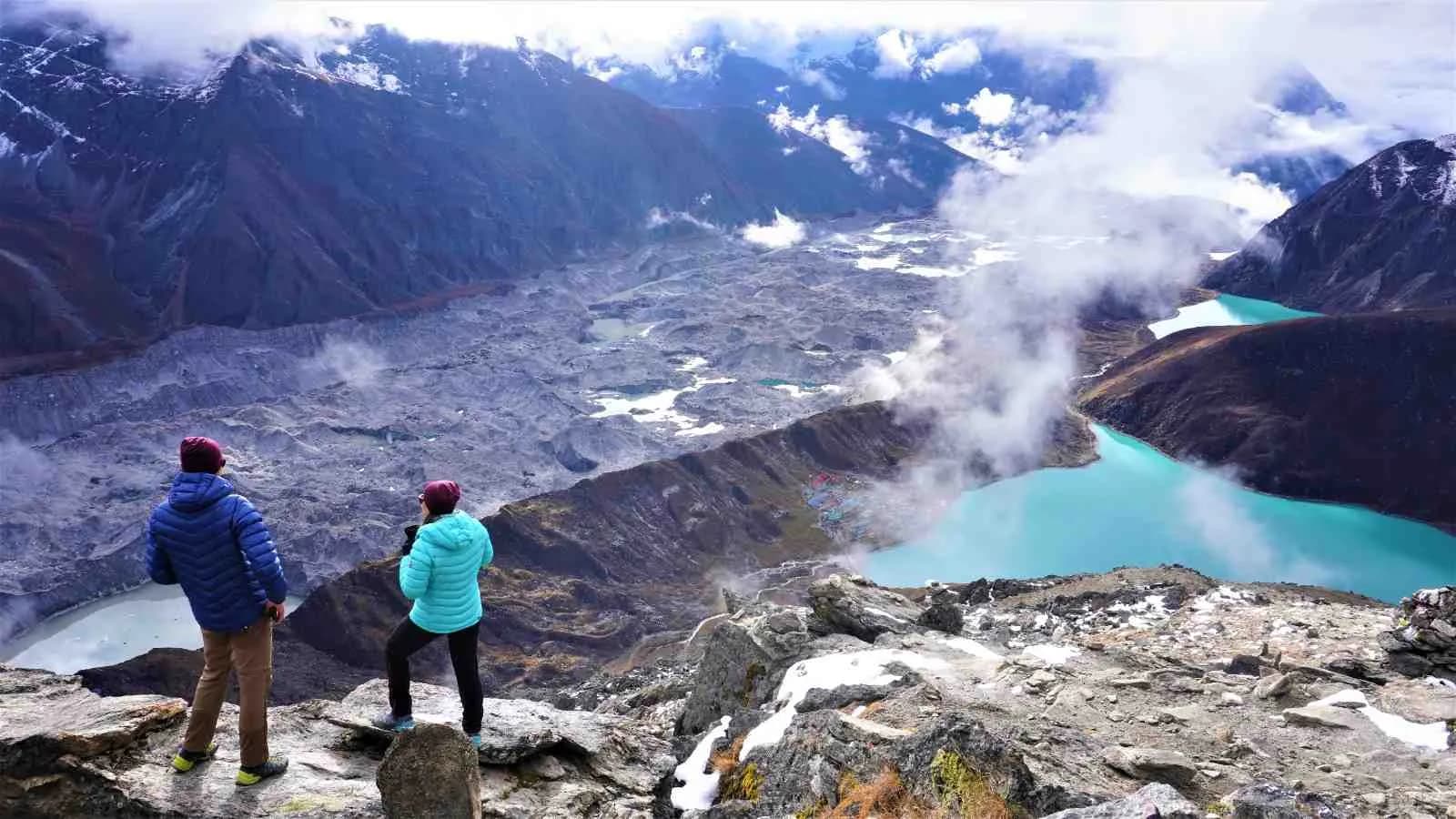 Trekker at Gokyo Lakes with Everest Base Camp panorama in background